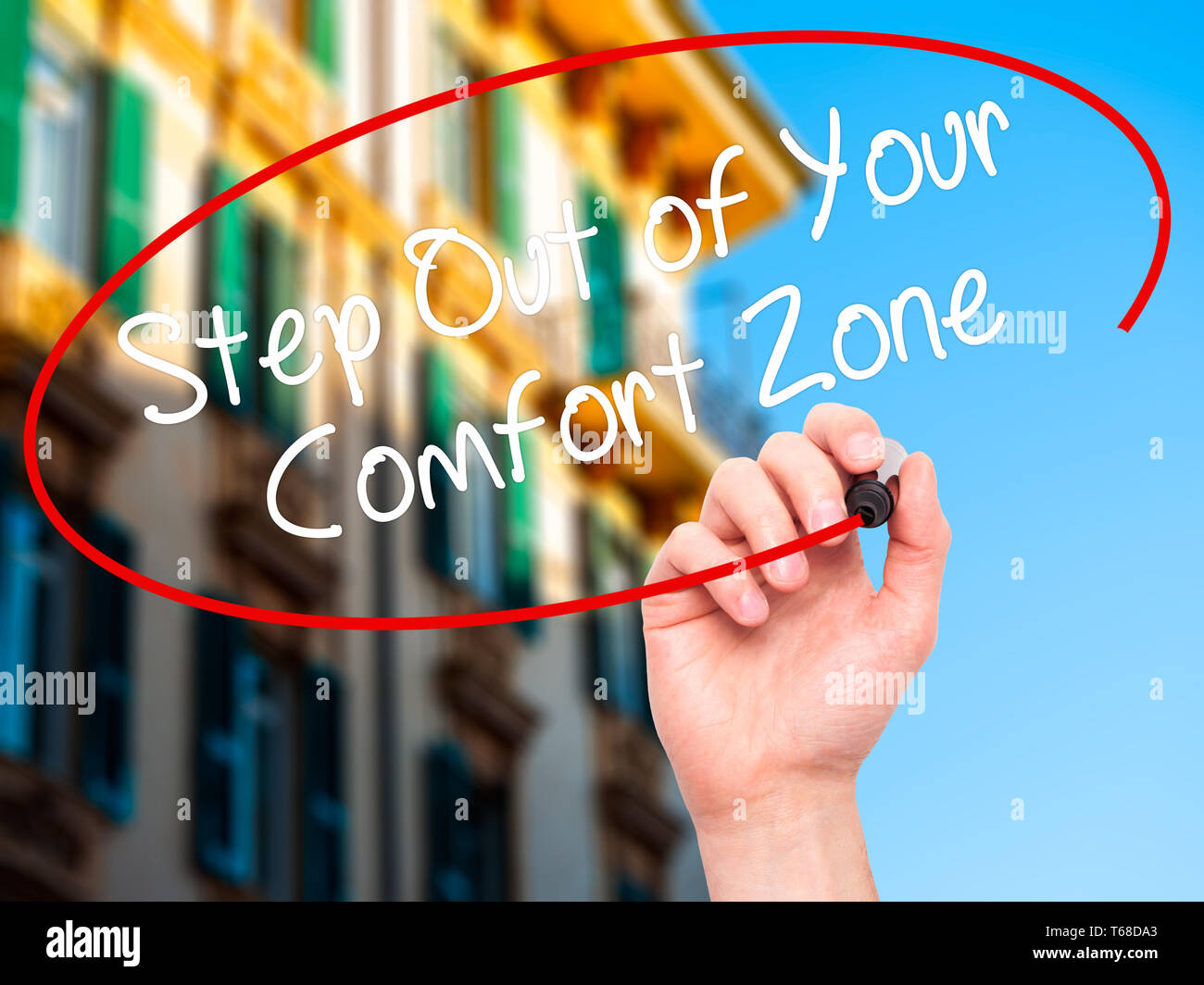 Man Hand writing Step Out of Your Comfort Zone with black marker on visual screen. Stock Photo