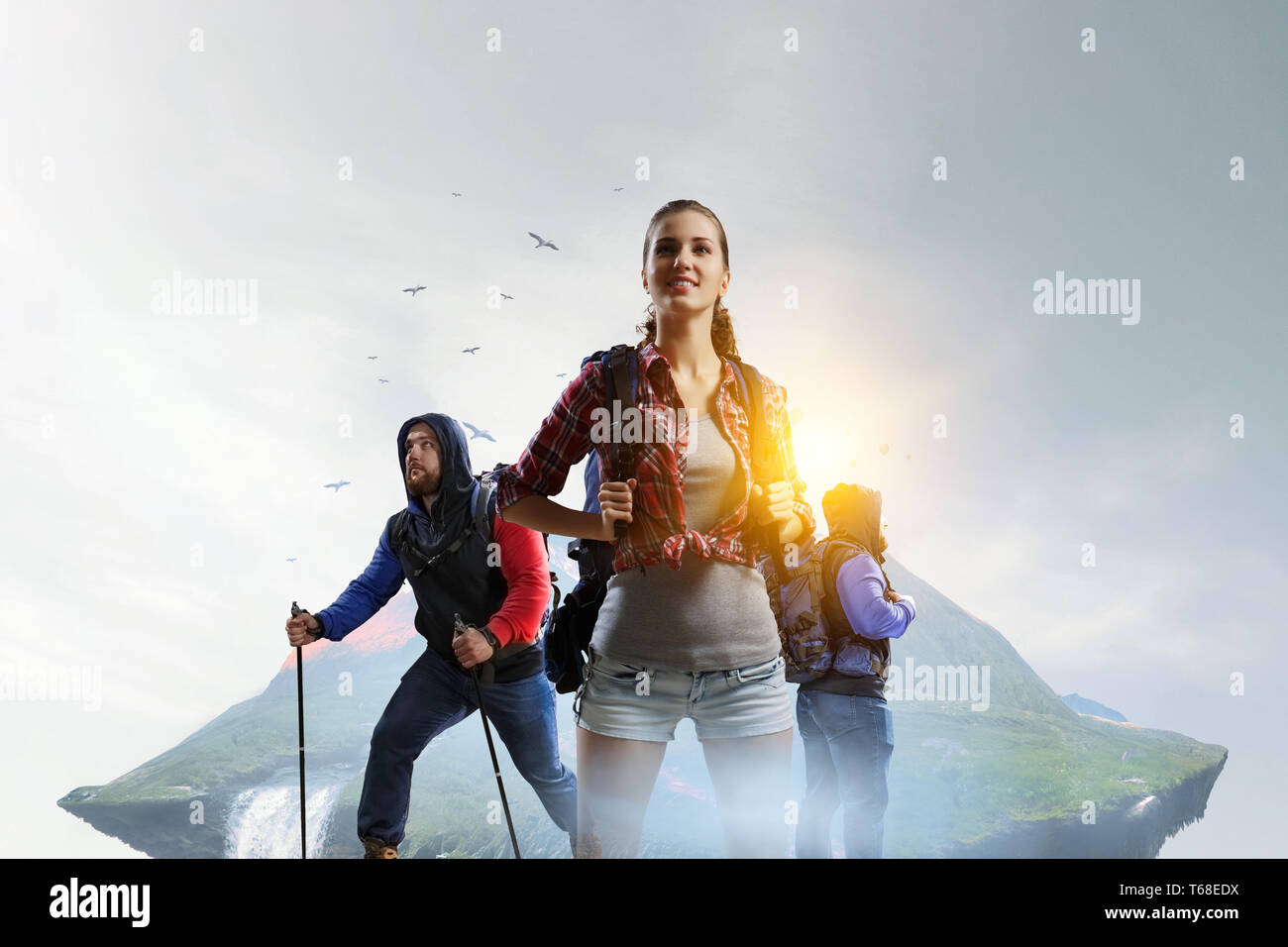 Travelling tourists with backpacks and sticks Stock Photo - Alamy