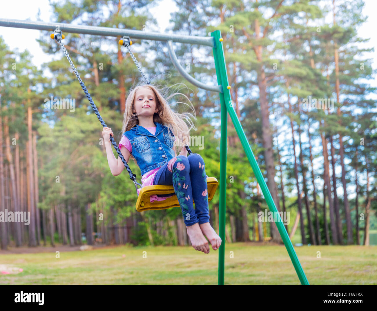 Children playing on swings hires stock