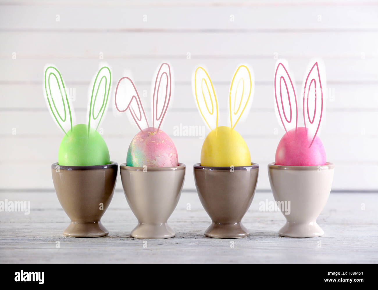 Cute bunny Easter eggs on light table Stock Photo