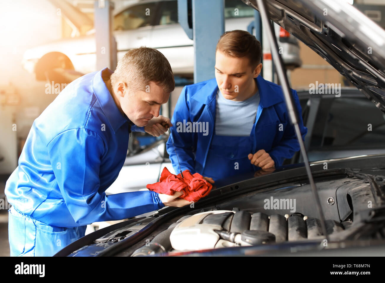 Male mechanics fixing car in service center Stock Photo - Alamy