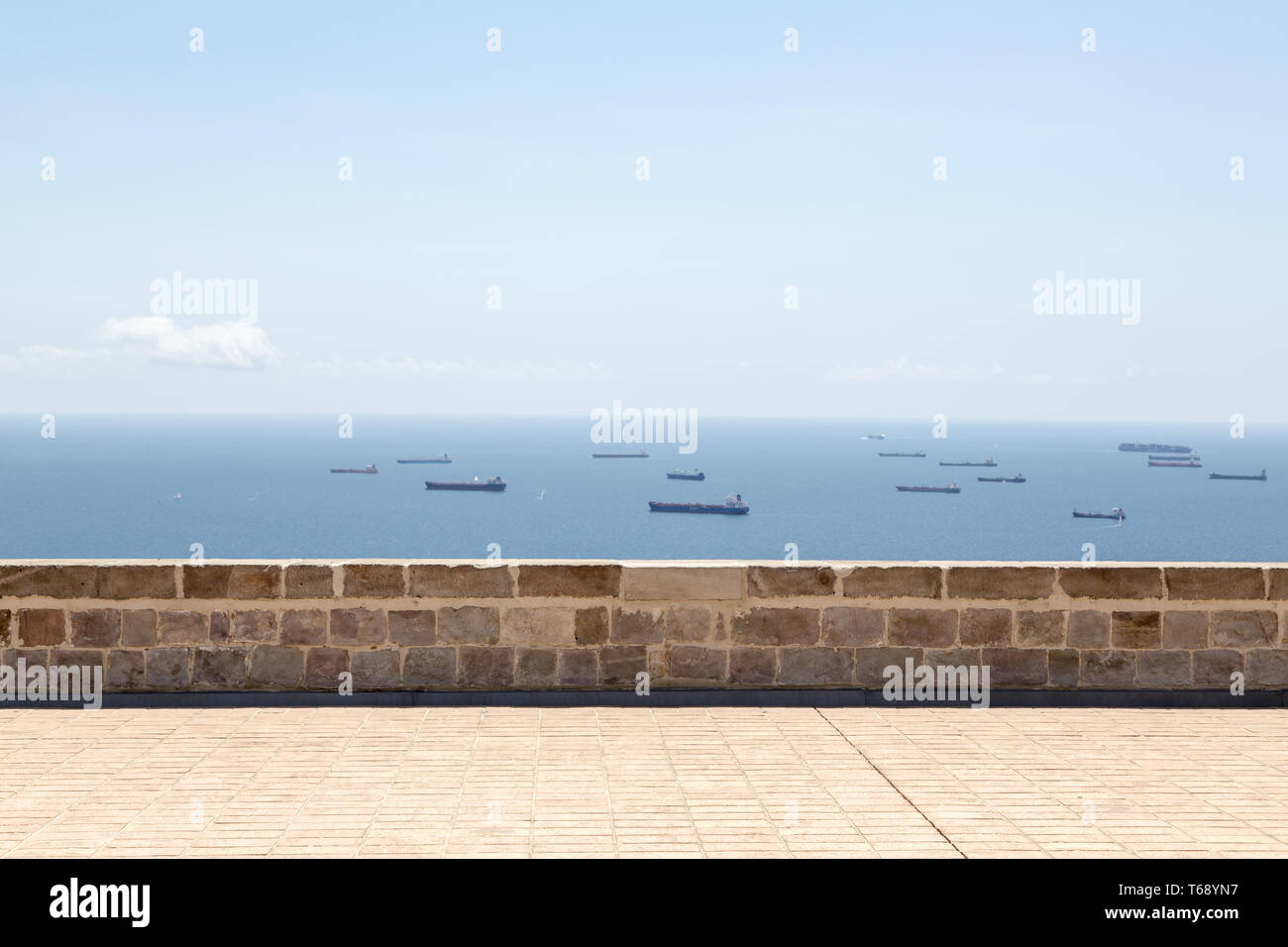 ancient wall with fleet of tankers behind Stock Photo