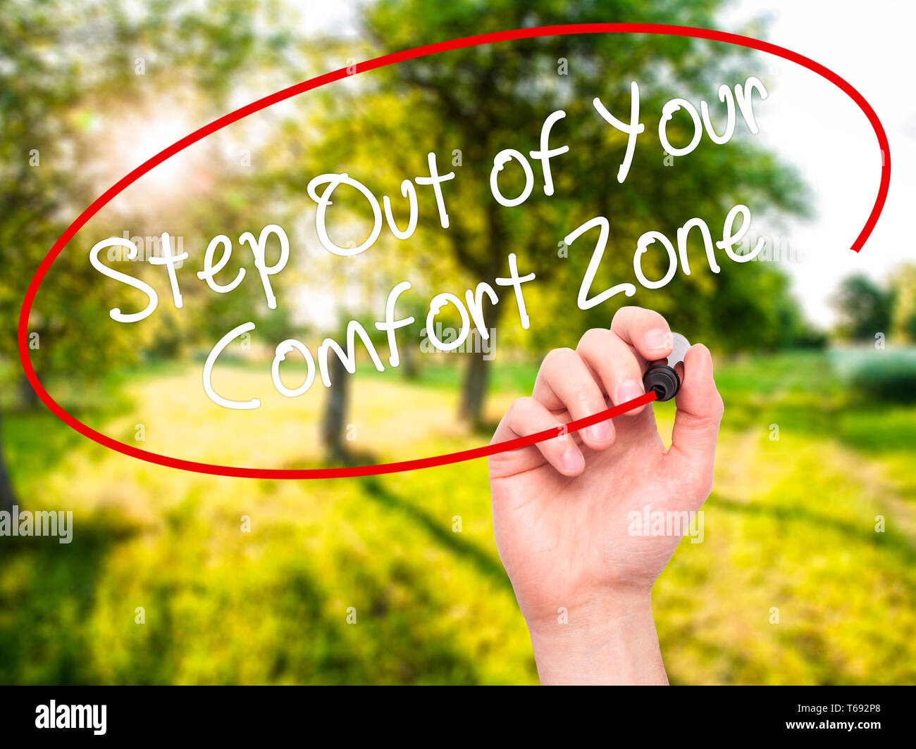 Man Hand writing Step Out of Your Comfort Zone with black marker on visual screen. Stock Photo