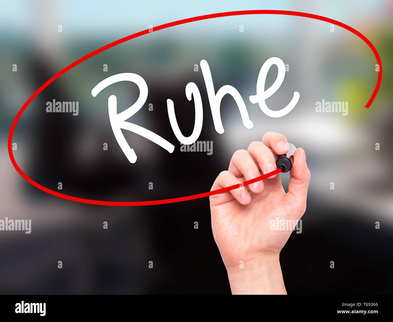 Man Hand writing Ruhe (Quiet in German) with black marker on visual