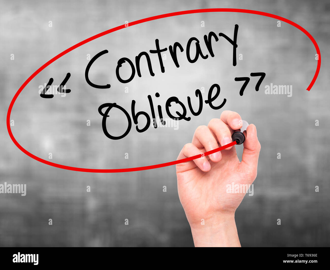 Man Hand writing Contrary - Oblique with black marker on visual screen Stock Photo