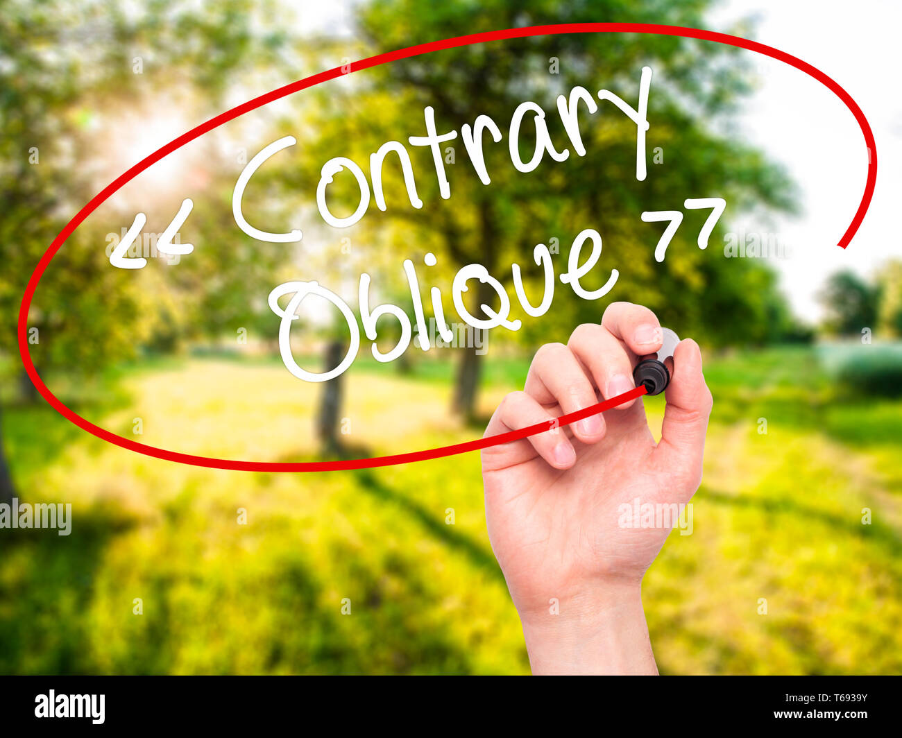 Man Hand writing Contrary - Oblique with black marker on visual screen Stock Photo