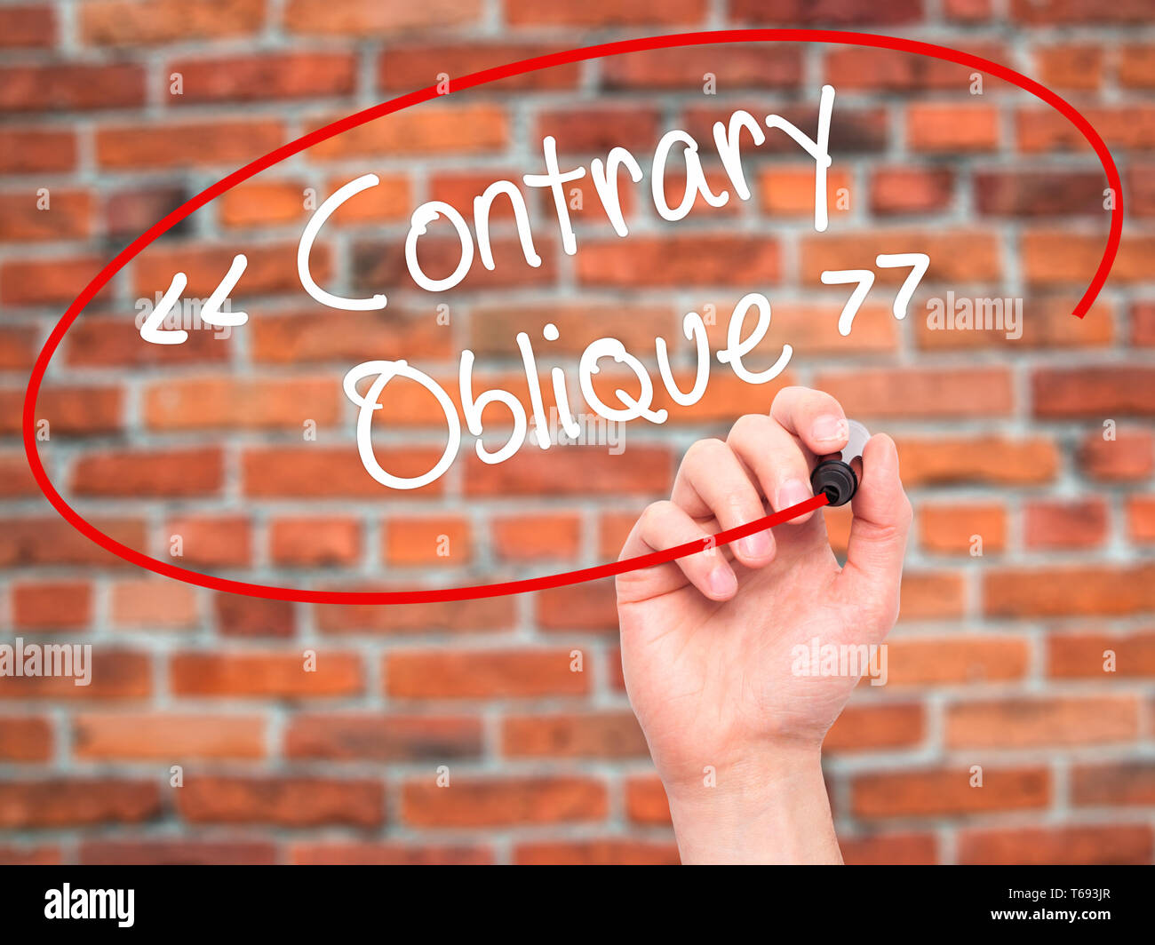 Man Hand writing Contrary - Oblique with black marker on visual screen Stock Photo