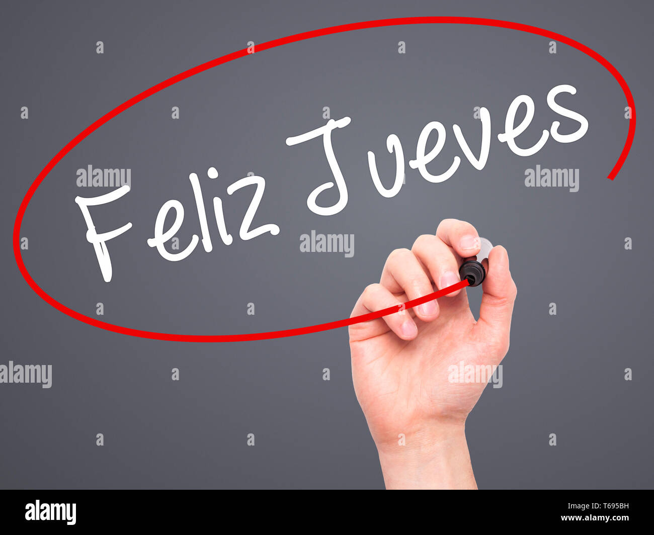 Man Hand writing Martes (Tuesday in Spanish) with black marker on