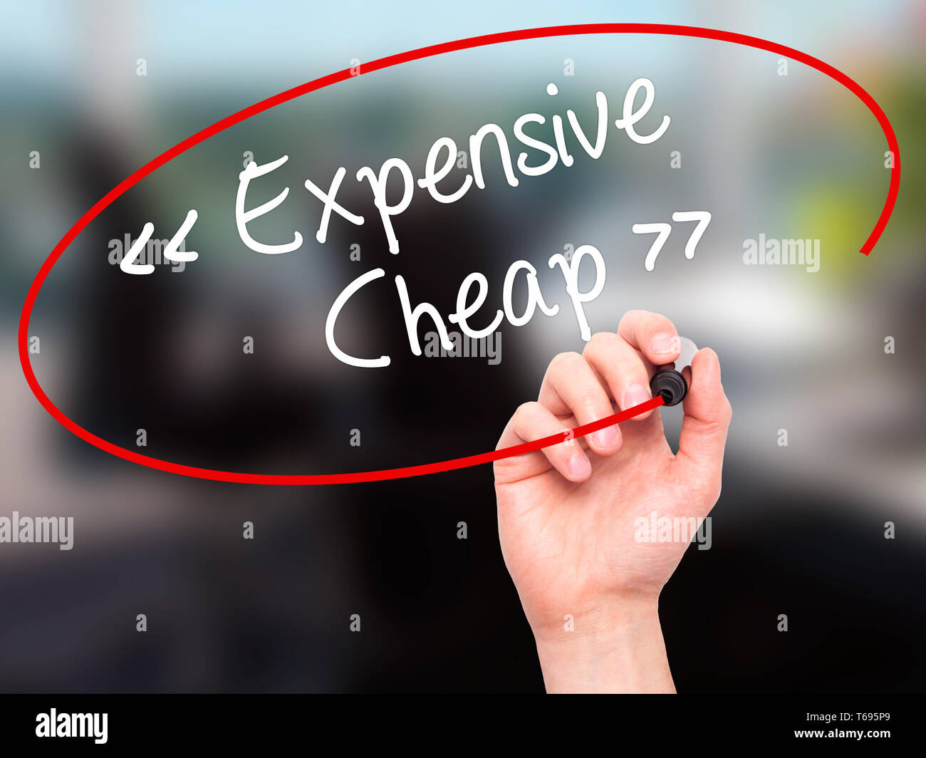 Man Hand writing Expensive - Cheap with black marker on visual screen. Stock Photo