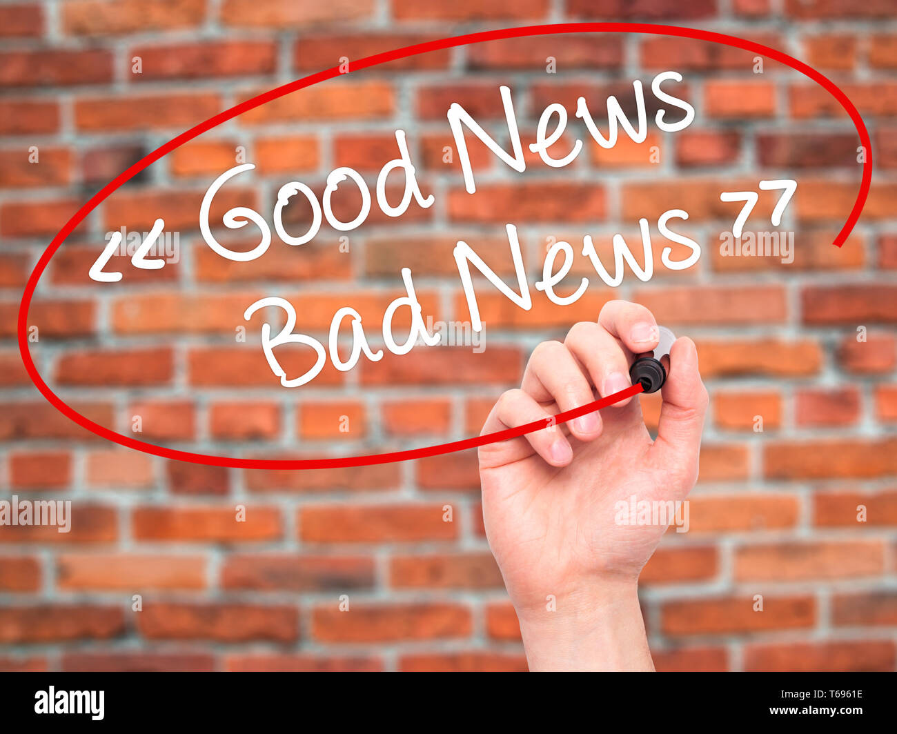 Man Hand writing Good News - Bad News with black marker on visual screen. Stock Photo