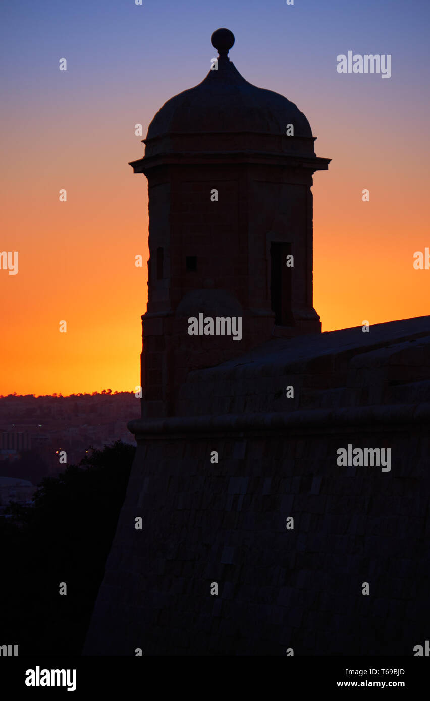St Peter and Paul Guard tower against backlight of the sunset, Valletta Stock Photo