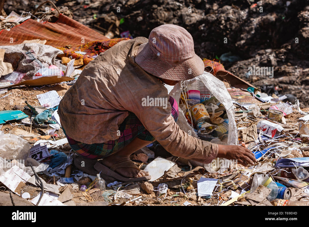 woman picking through Stung Meanchey, Cambodia dump for items to sell Stock Photo