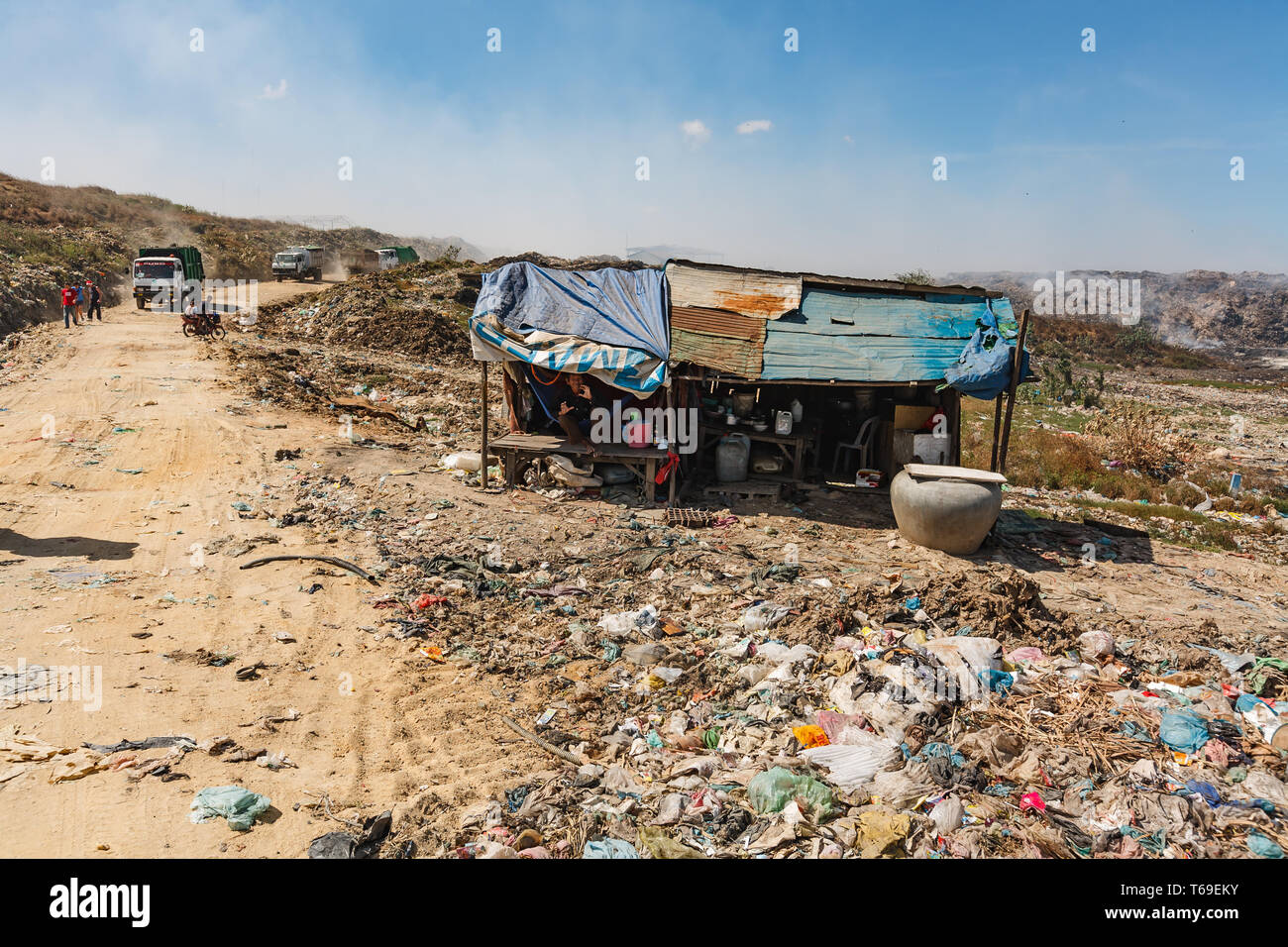 House and road for garbage trucks delivering waste to Stung Meanchey, the  Municipal Waste Dump located in southern Phnom Penh city, Cambodia.  The la Stock Photo