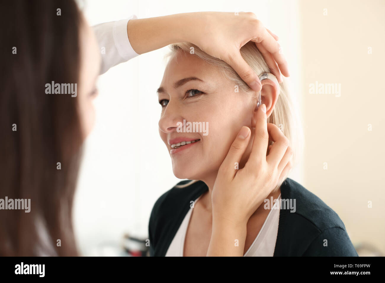 Otolaryngologist putting hearing aid hi-res stock photography and ...