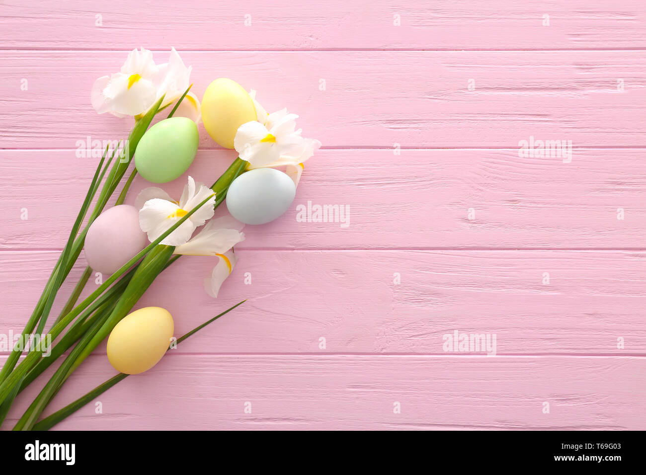 Easter eggs with spring flowers on color wooden background Stock Photo ...