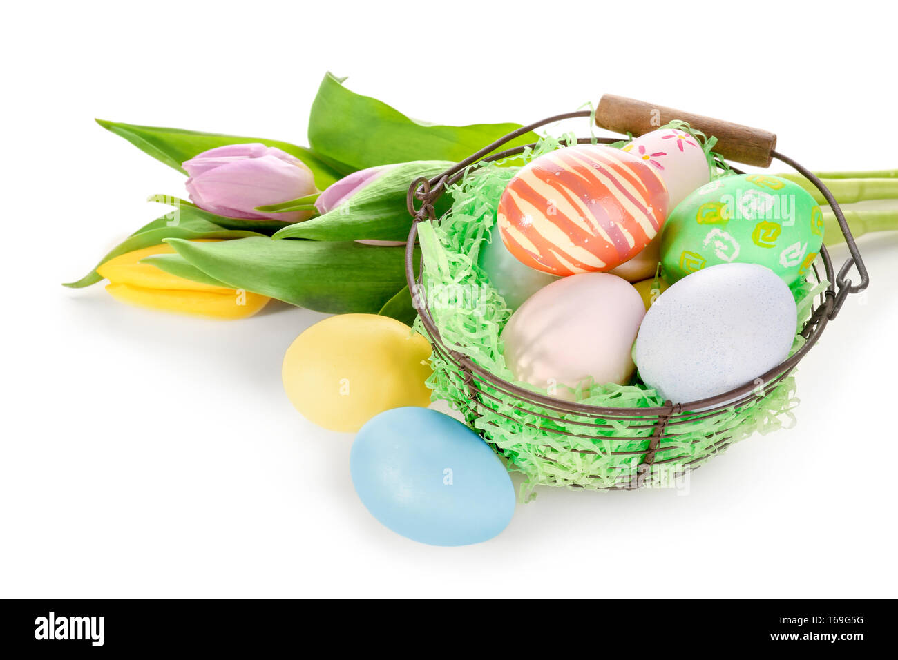 Easter basket with colorful eggs and bouquet of flowers on white ...