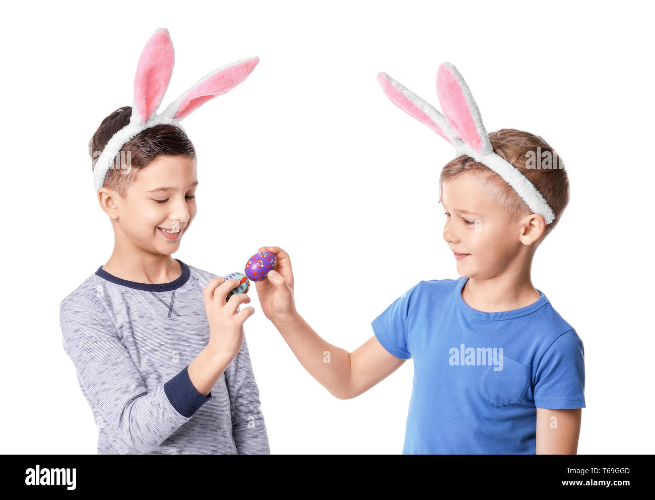 Cute little boys with bunny ears and Easter eggs on white background Stock Photo