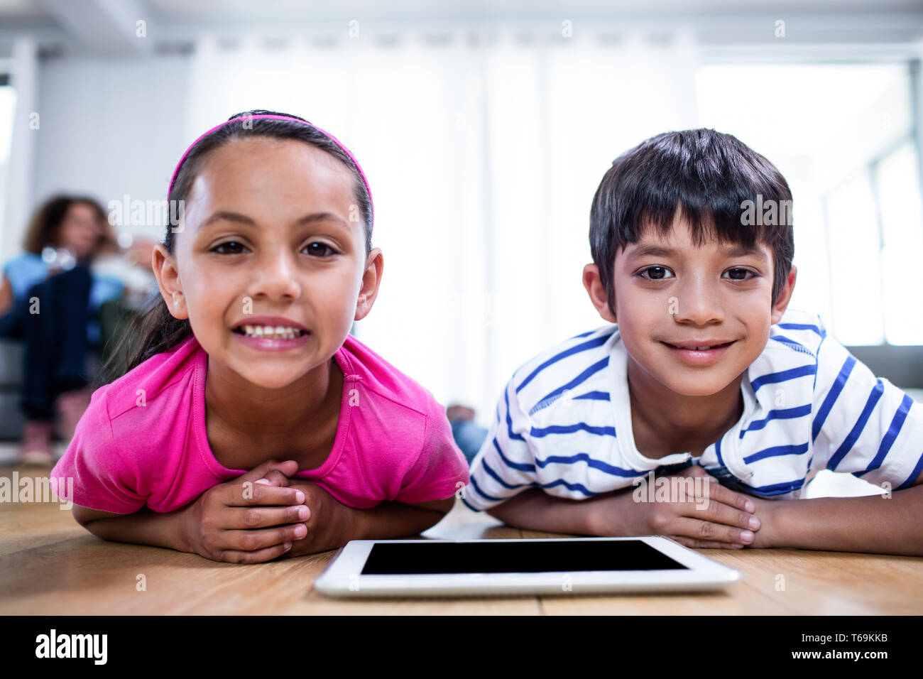 Portrait of brother and sister lying on floor with digital tablet Stock ...
