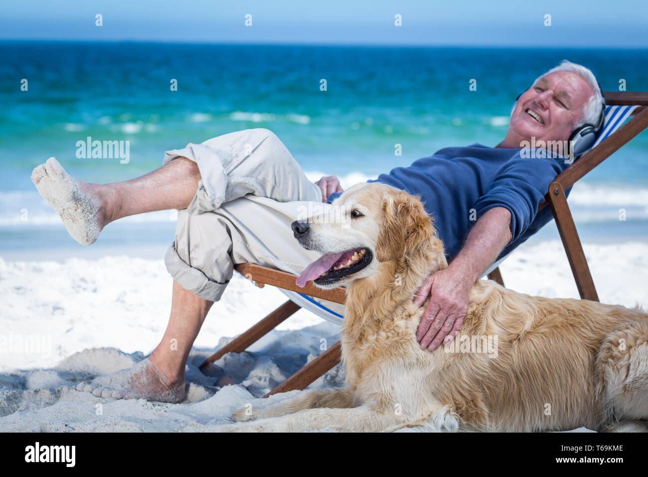 Mature man resting on a deck chair listening to music petting his dog