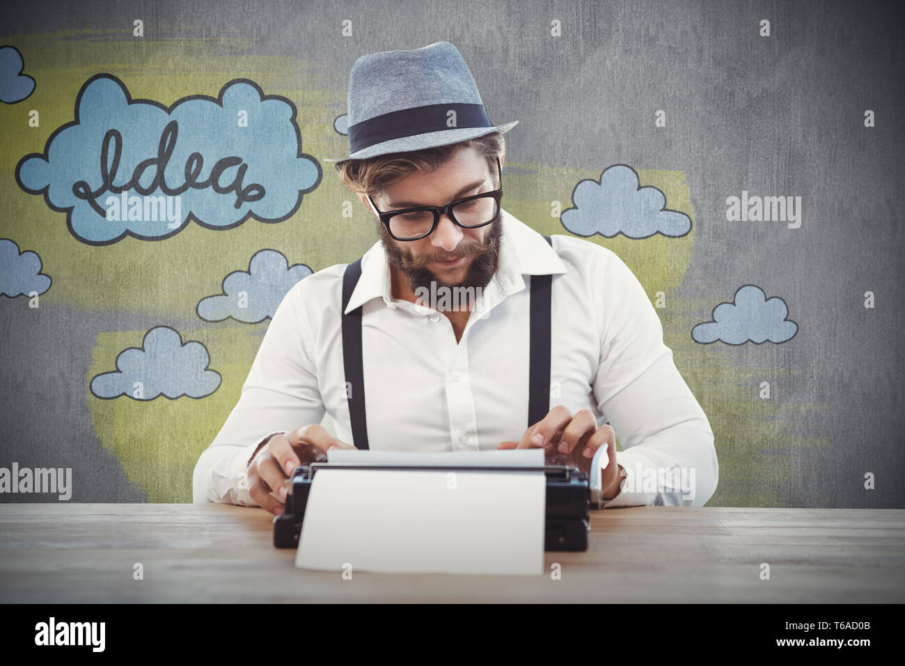 Composite image of hipster wearing eye glasses and hat working on typewriter Stock Photo