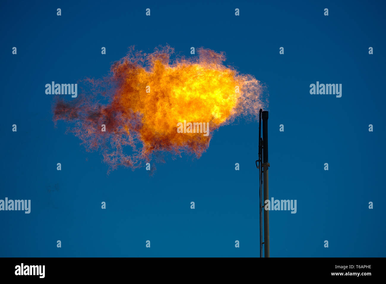 Midland, County / United States - April 21, 2019: Excess natural gas is burned off at an oil well site. Stock Photo