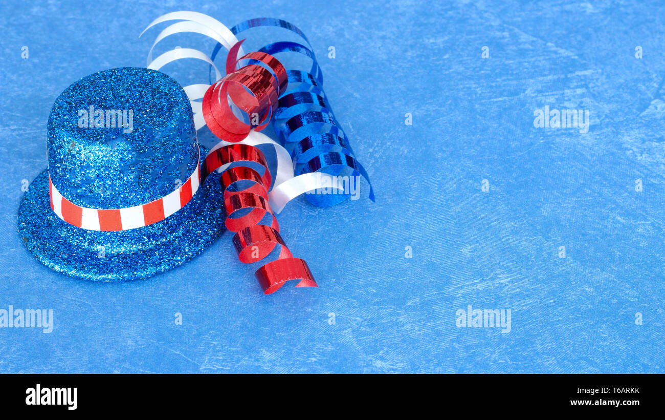 red white and blue hat and ribbon on a blue background with copy space Stock Photo