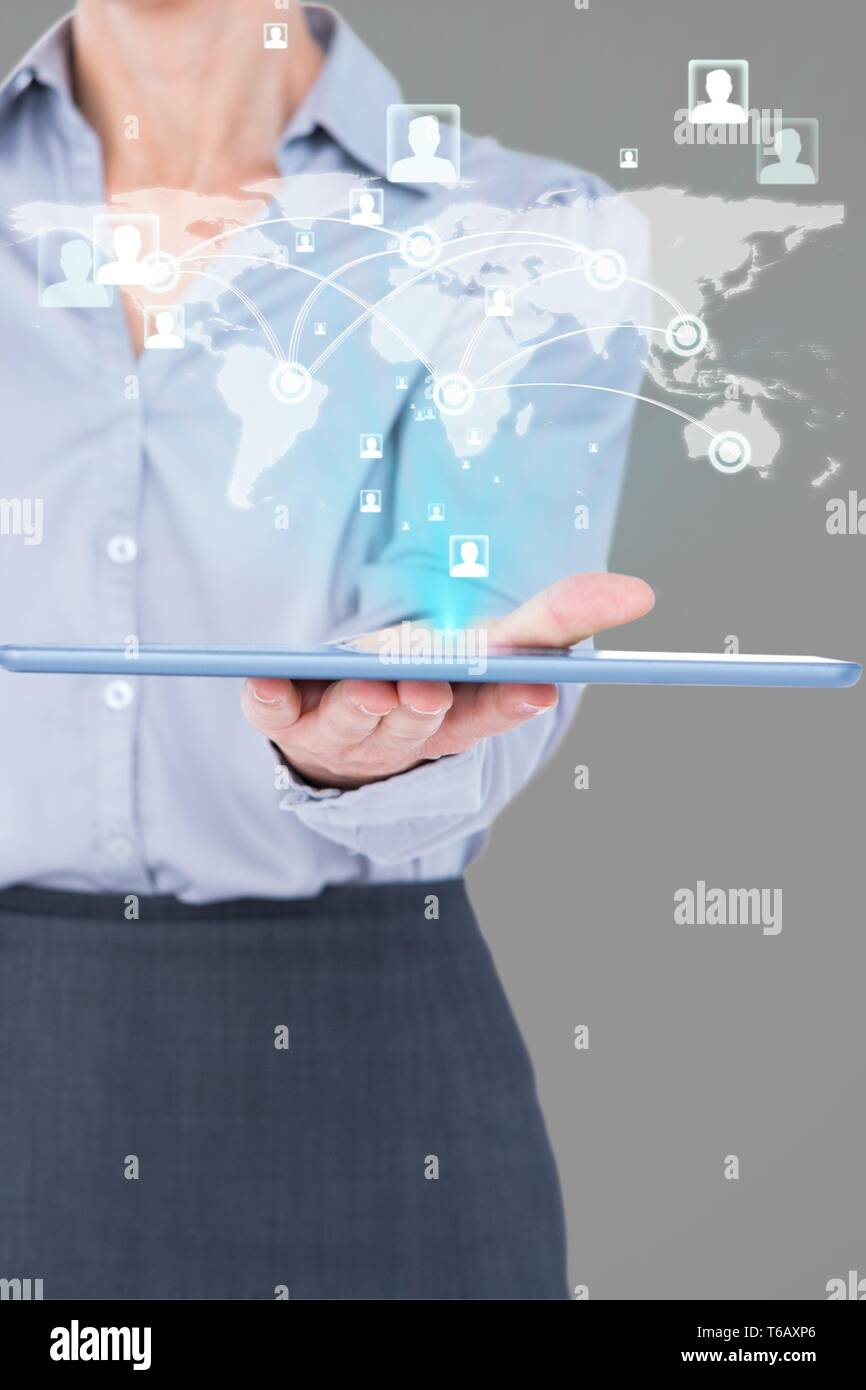 Composite image of businesswoman is holding a tablet with a hologram Stock Photo