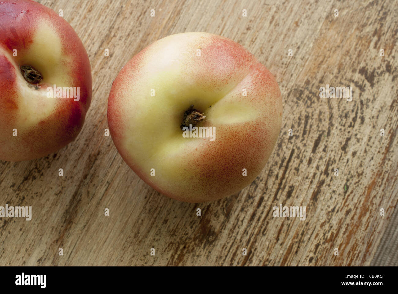 Peaches lie on weathered wooden surface Stock Photo