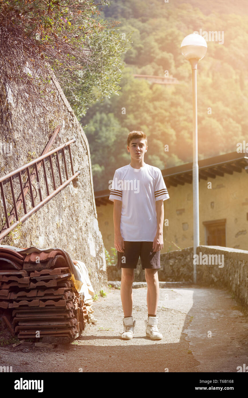 teenage boy in sportswear standing in a mountain village Stock Photo