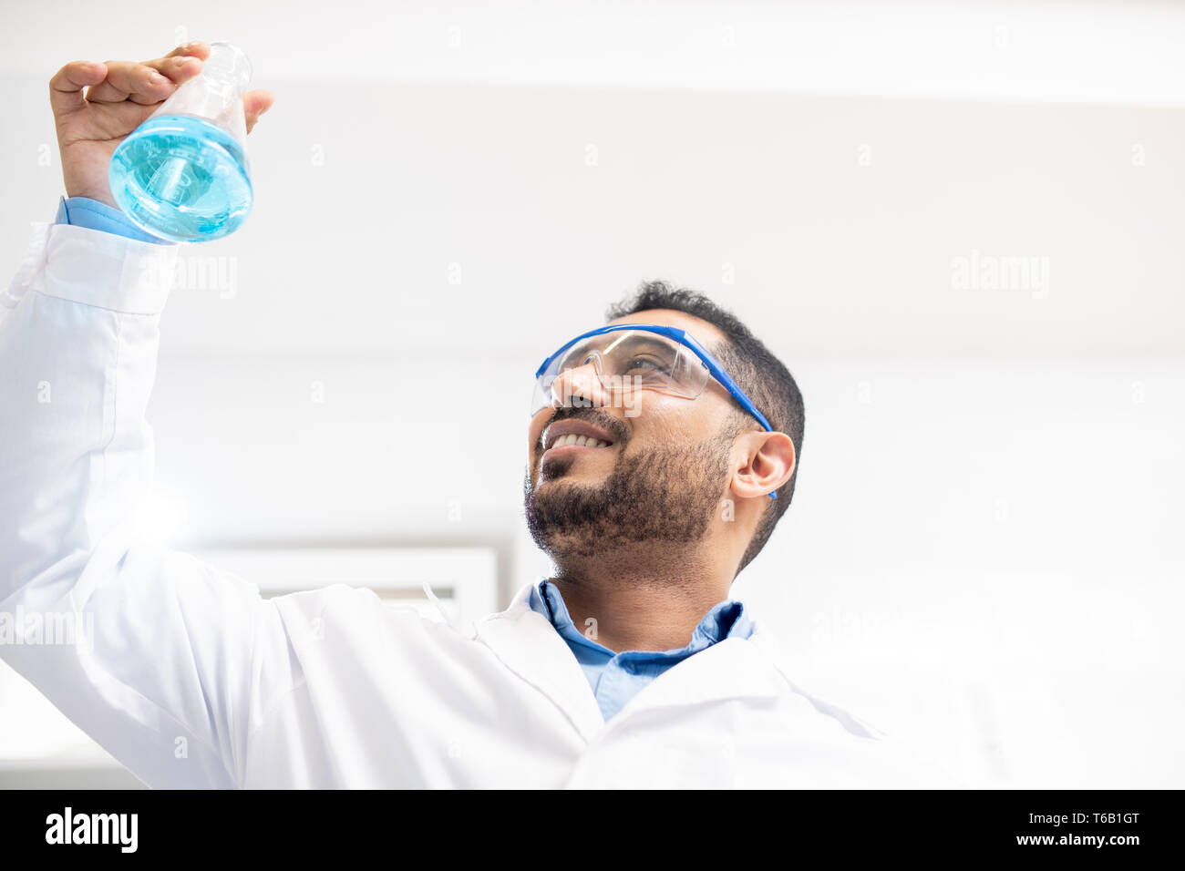 Cheerful chemist satisfied with test solution Stock Photo