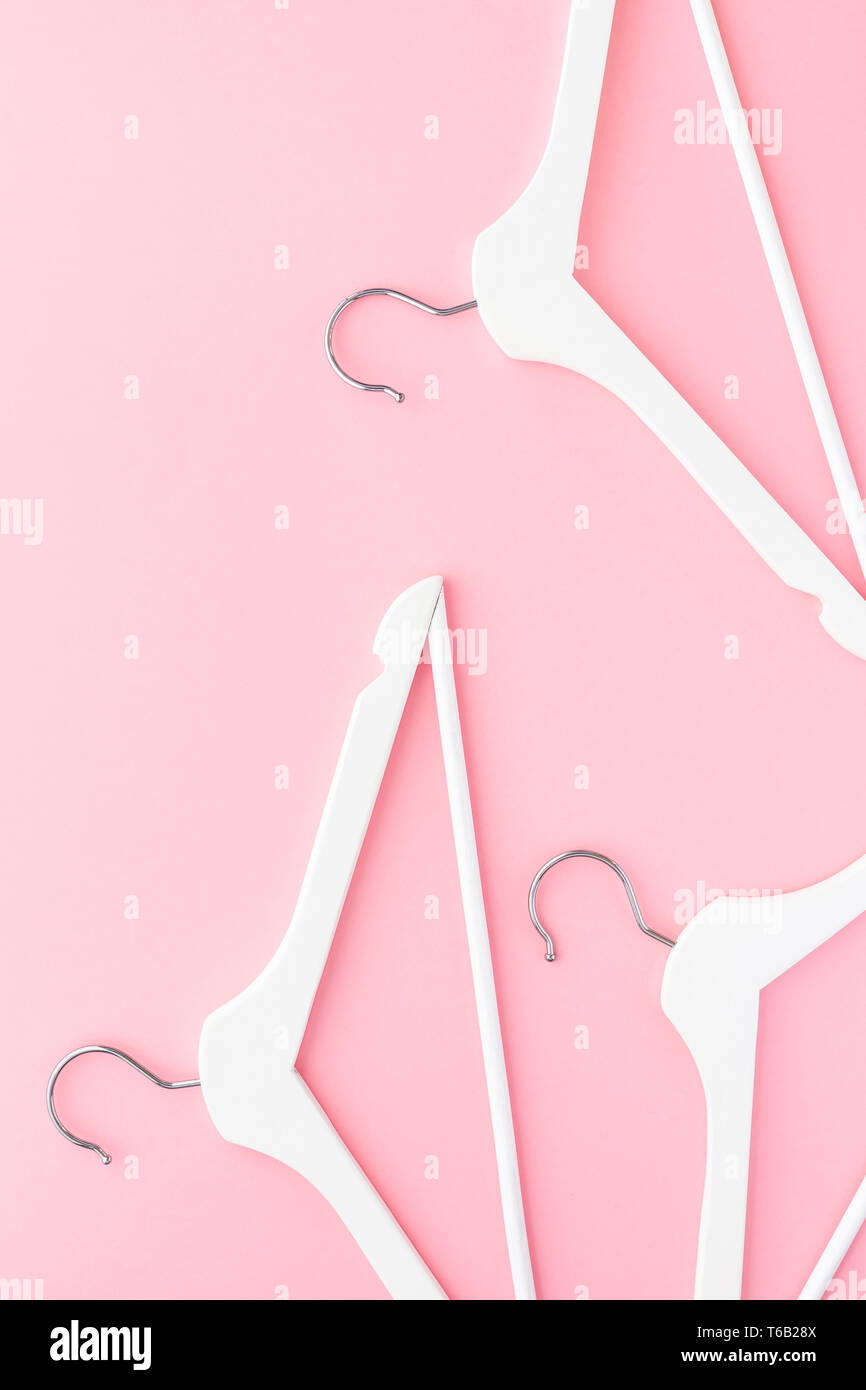 Creative top view flat lay white wooden hangers pastel millennial pink ...