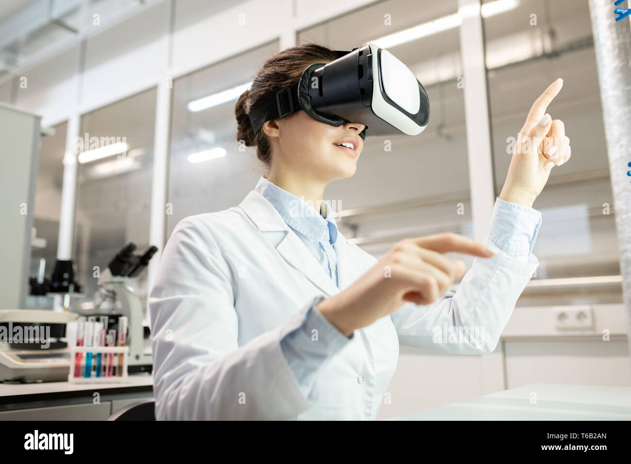 Laboratory worker watching video on VR device Stock Photo