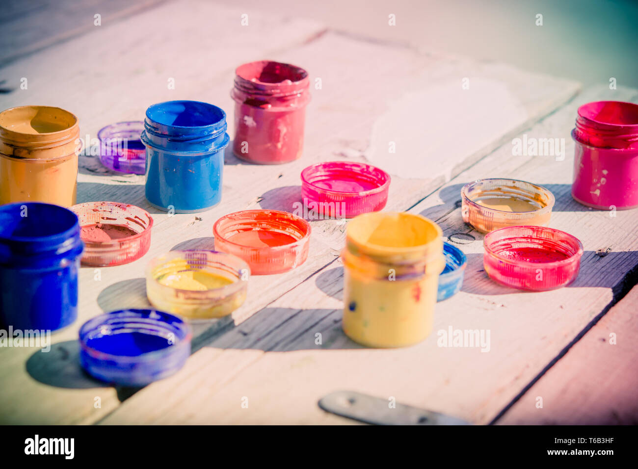 small gouache paint cans stand on a wooden table Stock Photo