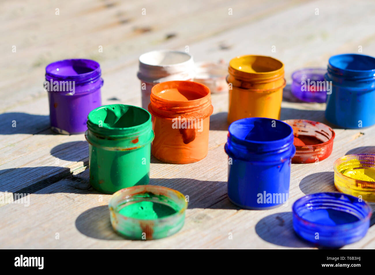 small gouache paint cans stand on a wooden table Stock Photo