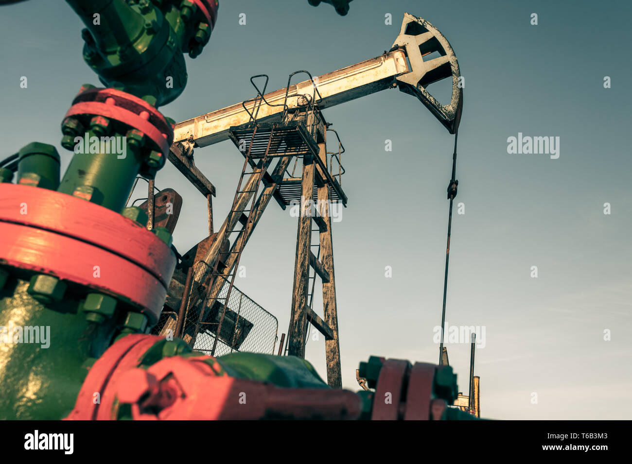 Oil pump jack and wellhead in the oilfield Stock Photo Alamy