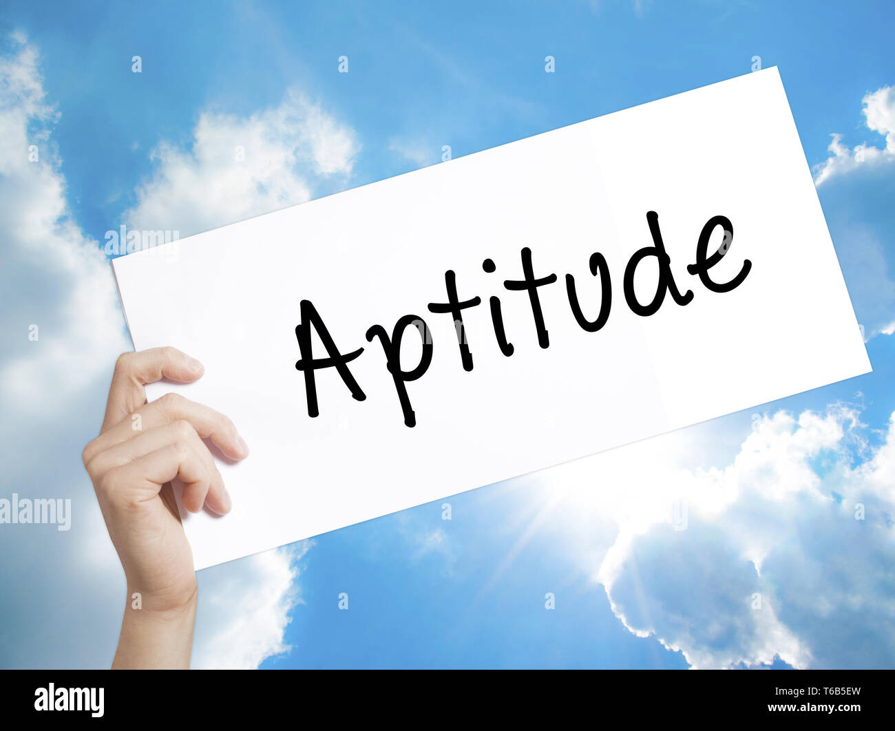 Aptitude Sign on white paper. Man Hand Holding Paper with text. Isolated on sky background Stock Photo