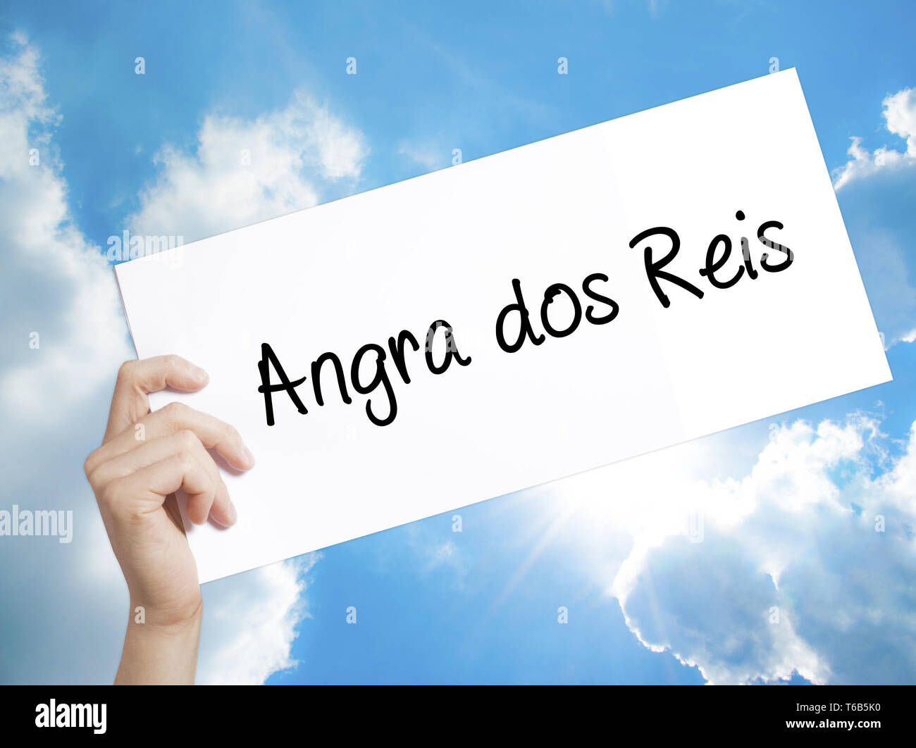 Angra dos Reis Sign on white paper. Man Hand Holding Paper with text. Isolated on sky background Stock Photo