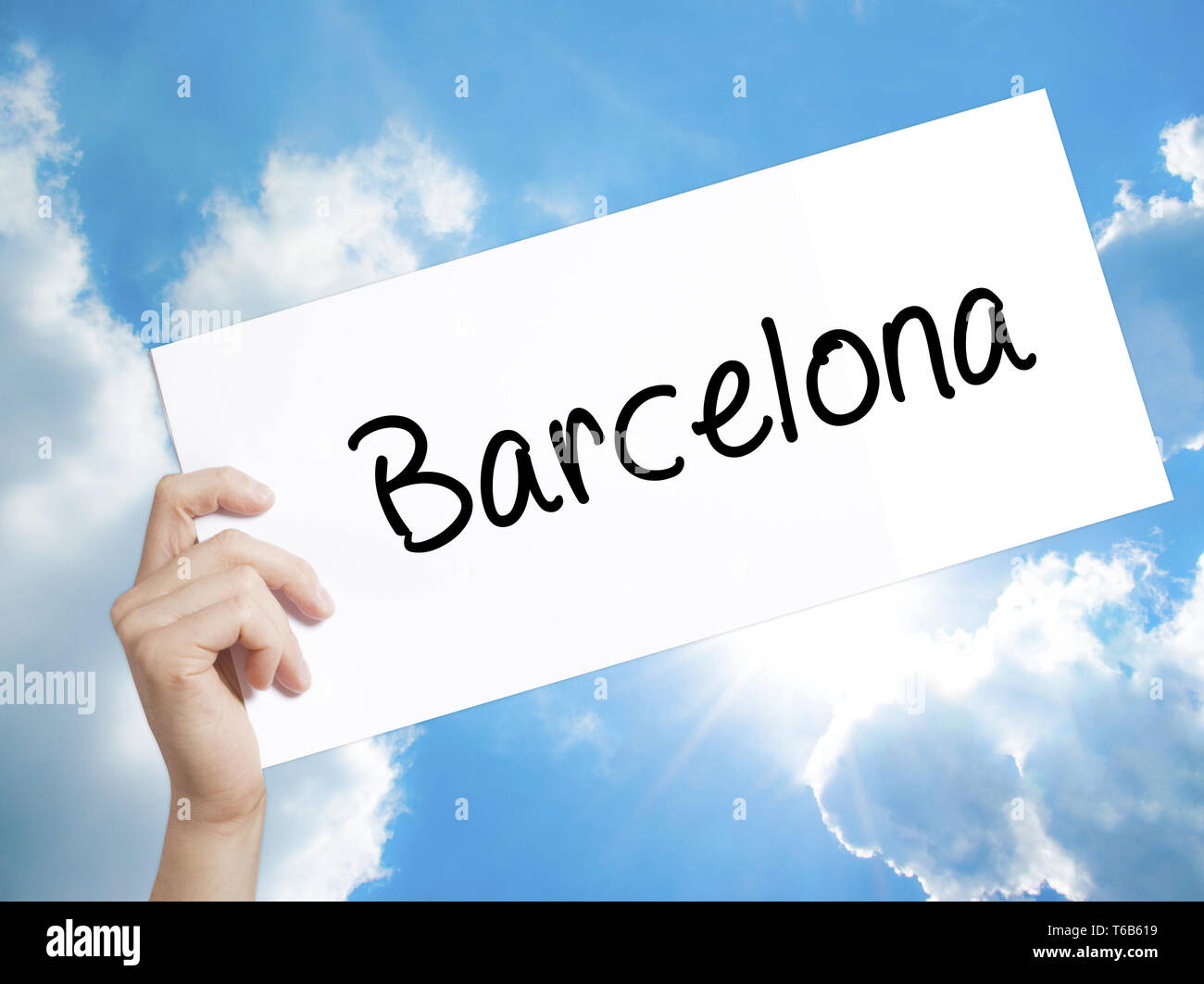 Barcelona Sign on white paper. Man Hand Holding Paper with text. Isolated on sky background Stock Photo