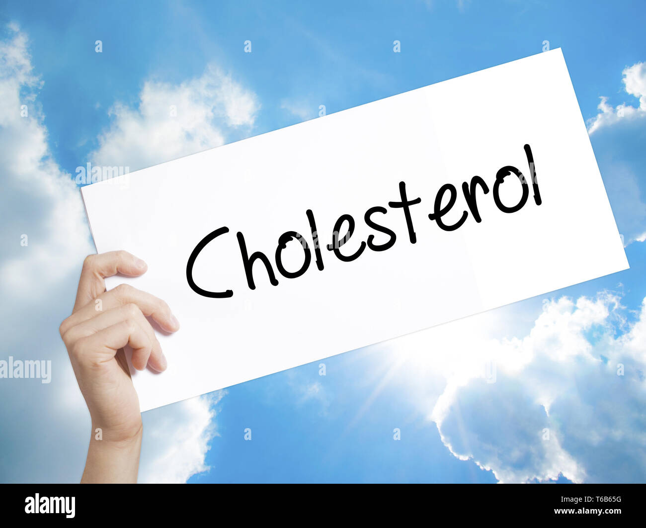 Cholesterol Sign on white paper. Man Hand Holding Paper with text. Isolated on sky background. Stock Photo