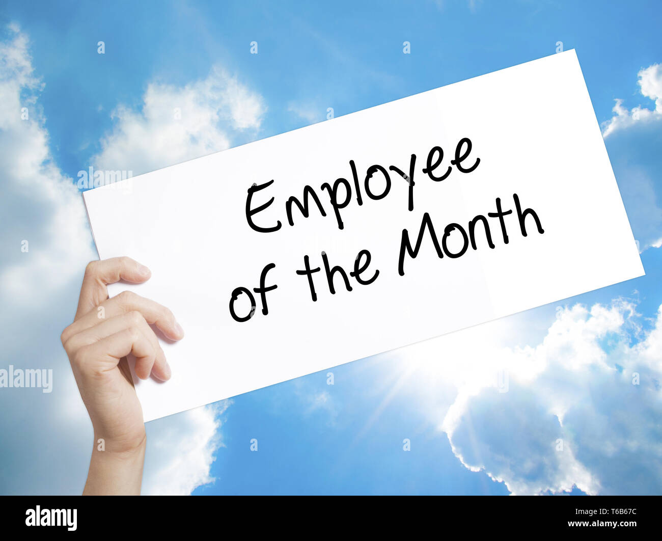 Employee of the Month  Sign on white paper. Man Hand Holding Paper with text. Isolated on sky background Stock Photo