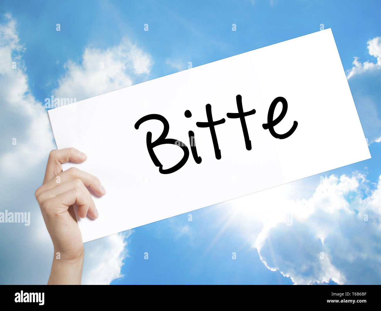 Bitte (Please in German) Sign on white paper. Man Hand Holding Paper with text. Isolated on sky background Stock Photo