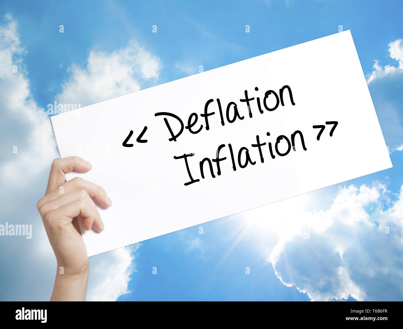 Deflation - Inflation Sign on white paper. Man Hand Holding Paper with ...