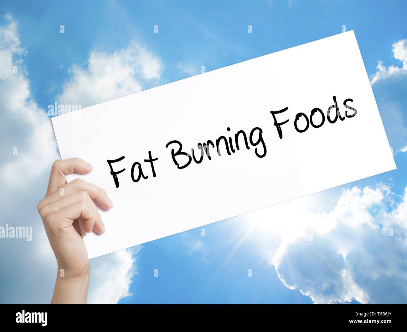 Fat Burning Foods Sign on white paper. Man Hand Holding Paper with text. Isolated on sky background Stock Photo