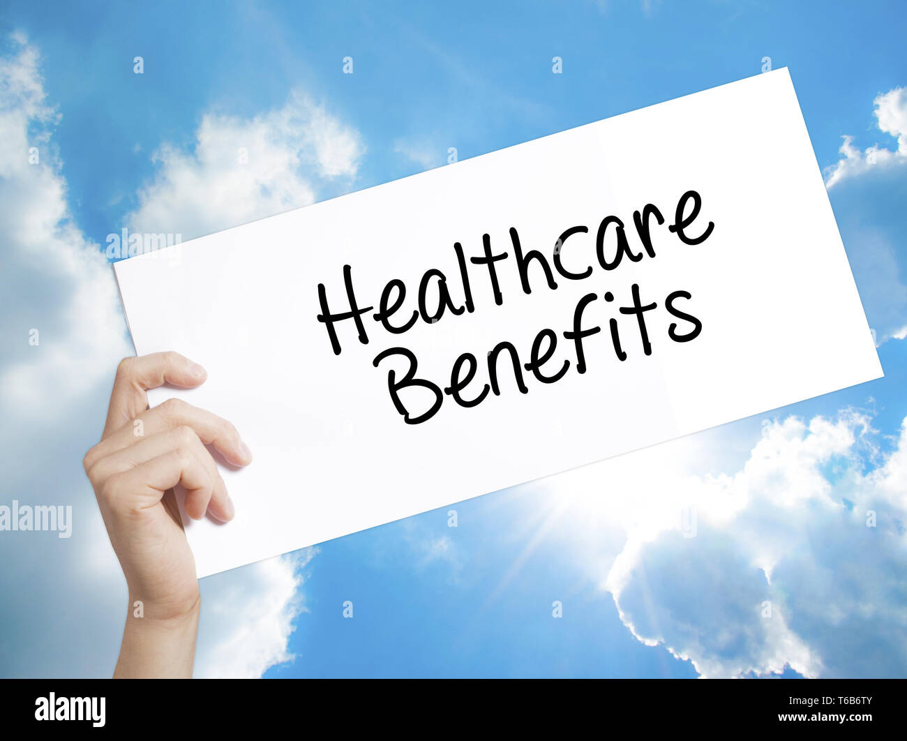 Healthcare Benefits Sign on white paper. Man Hand Holding Paper with