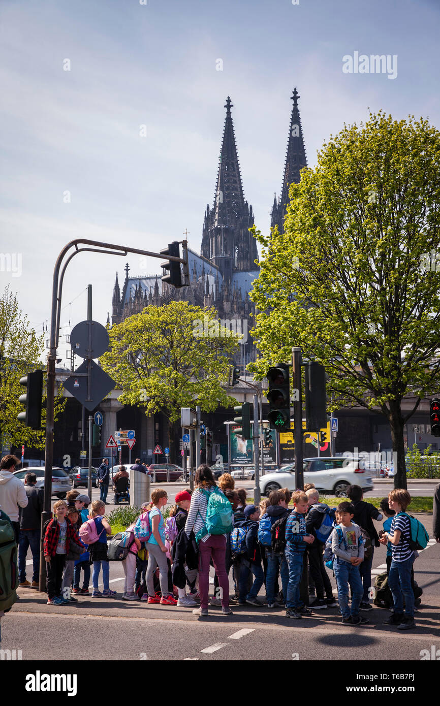 children are standing at a traffic light at the Rheinuferstrasse, the cathedral, Cologne, Germany.  Kinder stehen an einer Ampel an der Rheinuferstras Stock Photo