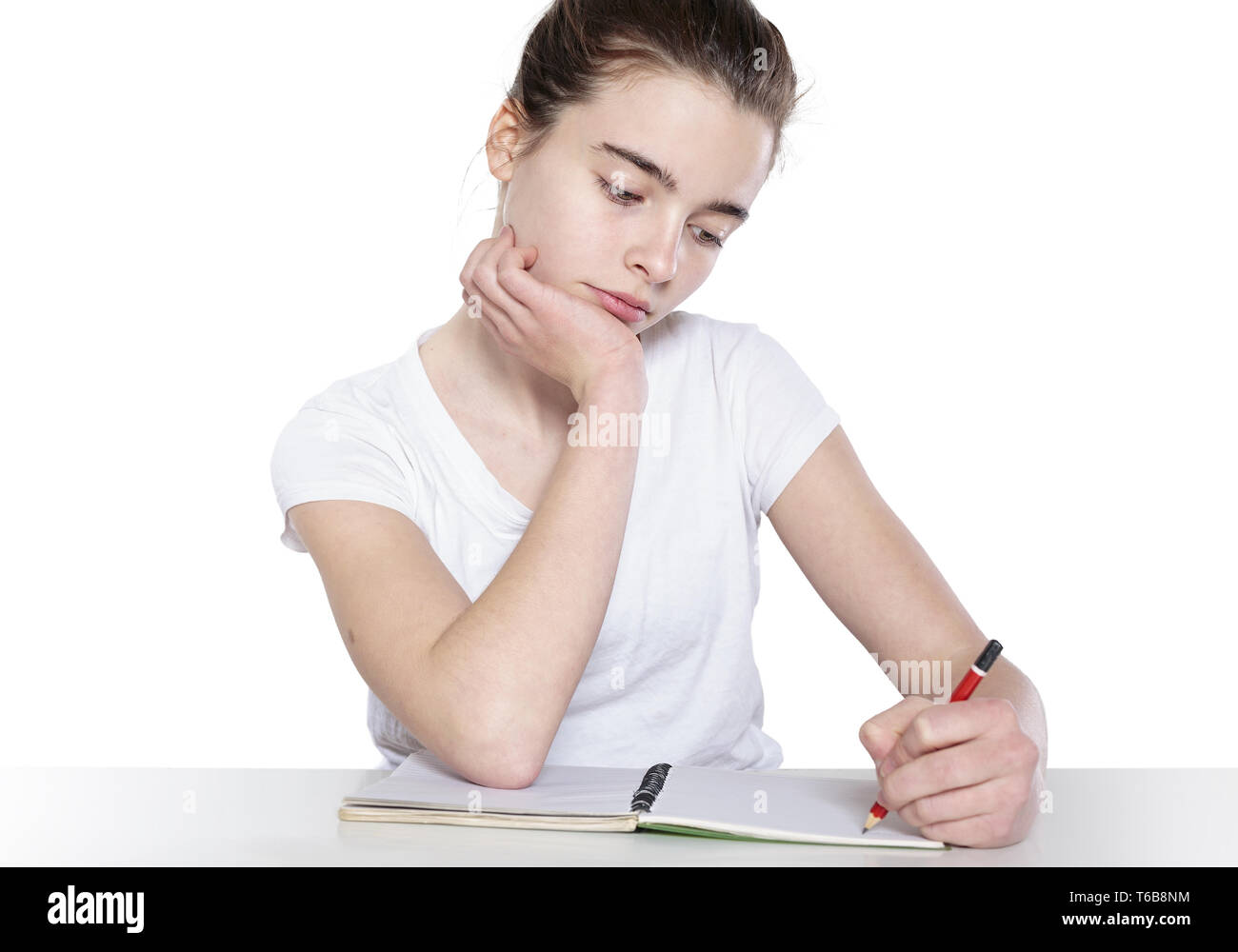 bored teenage girl is doing her homework Stock Photo
