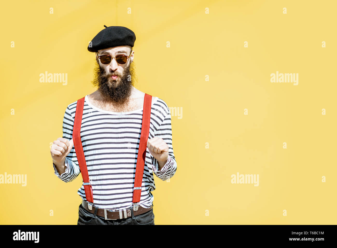 Portrait of a stylish bearded man dressed in striped shirt, suspenders ...