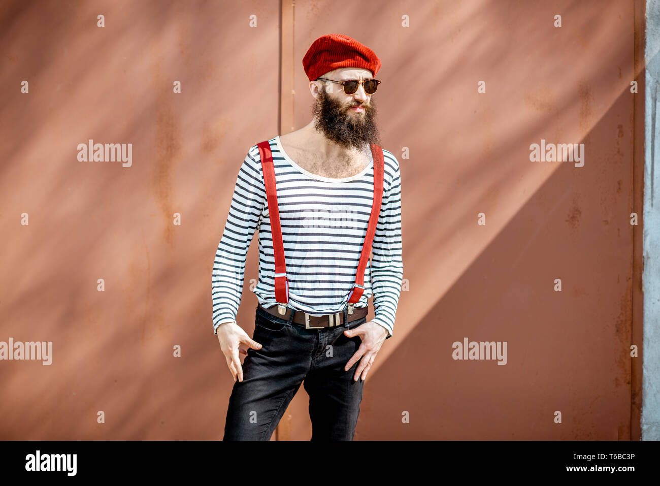 Portrait of a stylish bearded man dressed in striped shirt, suspenders ...