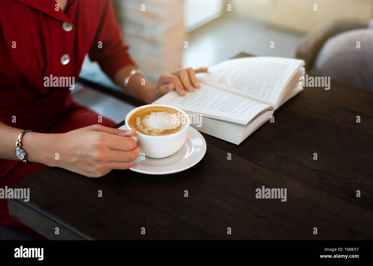 Girl having coffee in the bar and reading a book Stock Photo