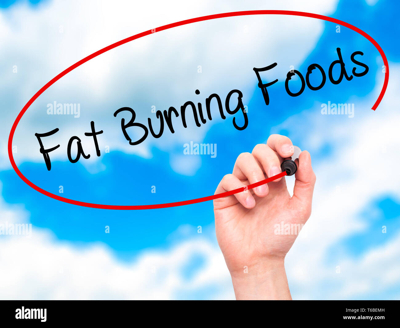 Man Hand writing Fat Burning Foods with black marker on visual screen Stock Photo